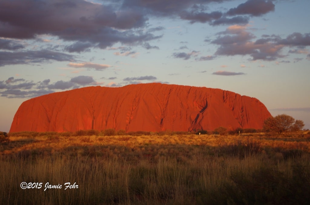 Here's Uluru, glowing its famous orange in the sunset.