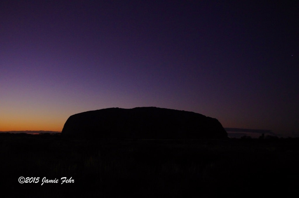 At near fully dusk, Uluru is a just silhouette.